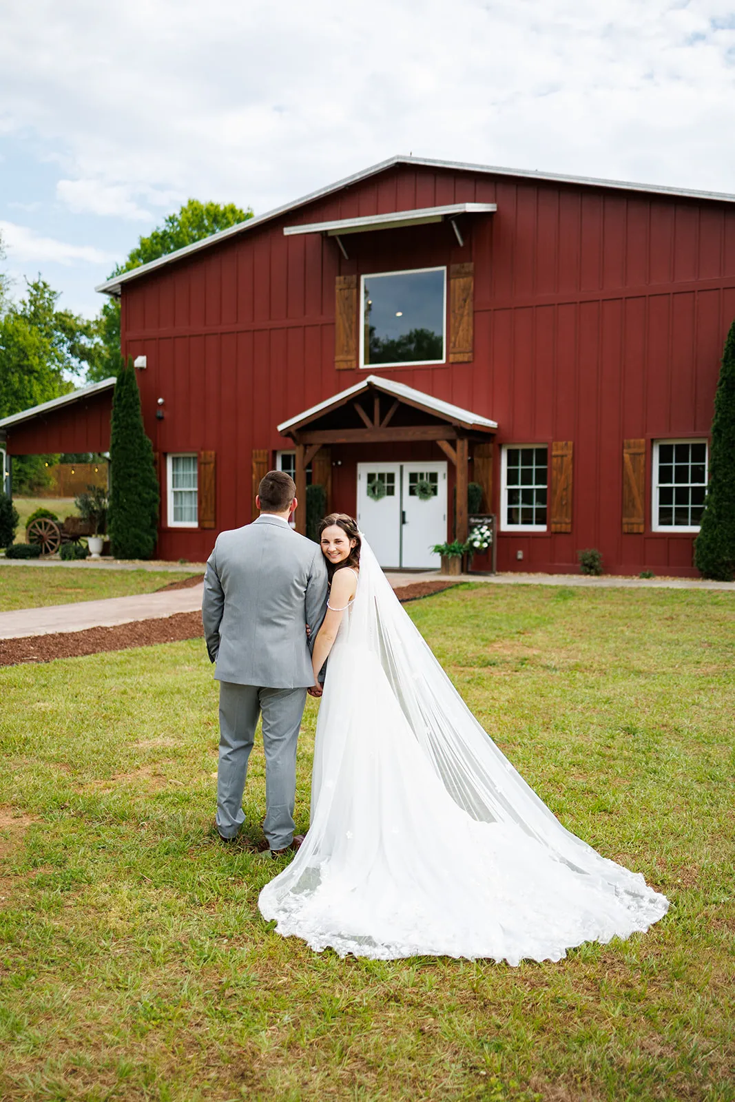 Couple walking together in front of the red barn at The Heritage Barn
