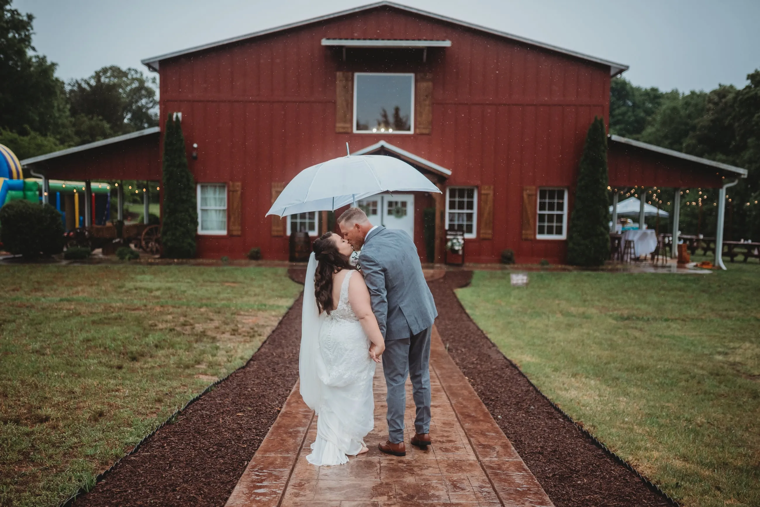 Couple walking together in front of the red barn at The Heritage Barn near Hickory, NC
