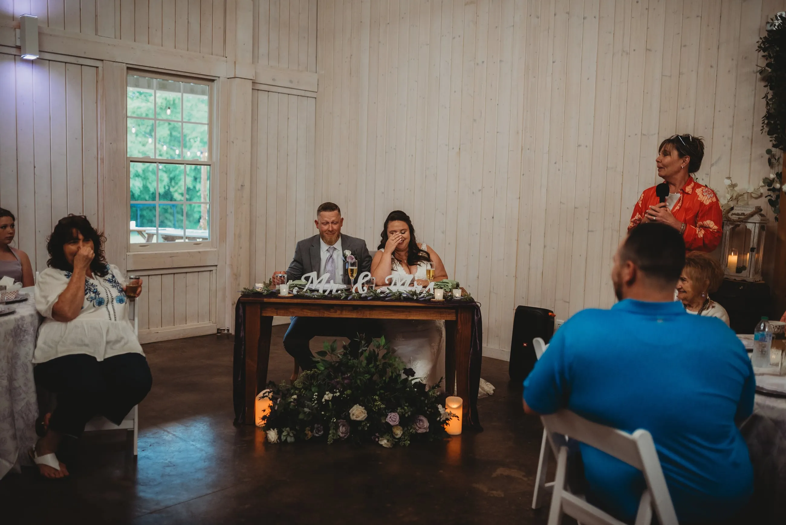 Couple seated at their sweetheart table during the reception inside The Heritage Barn
