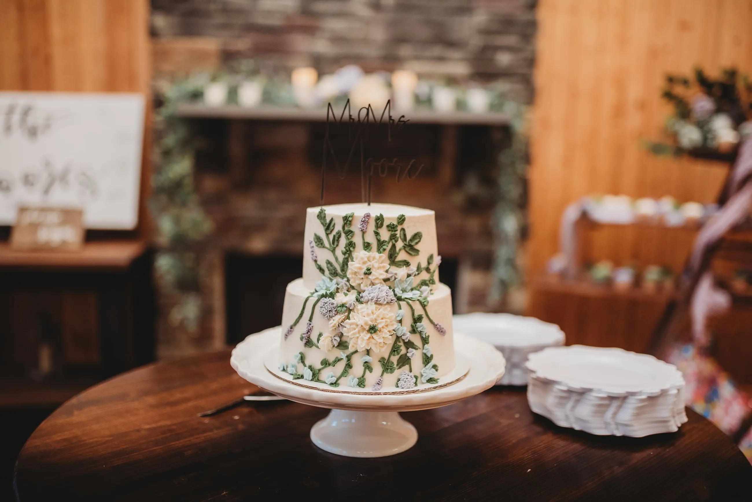 Wedding cake displayed on a round table inside The Heritage Barn