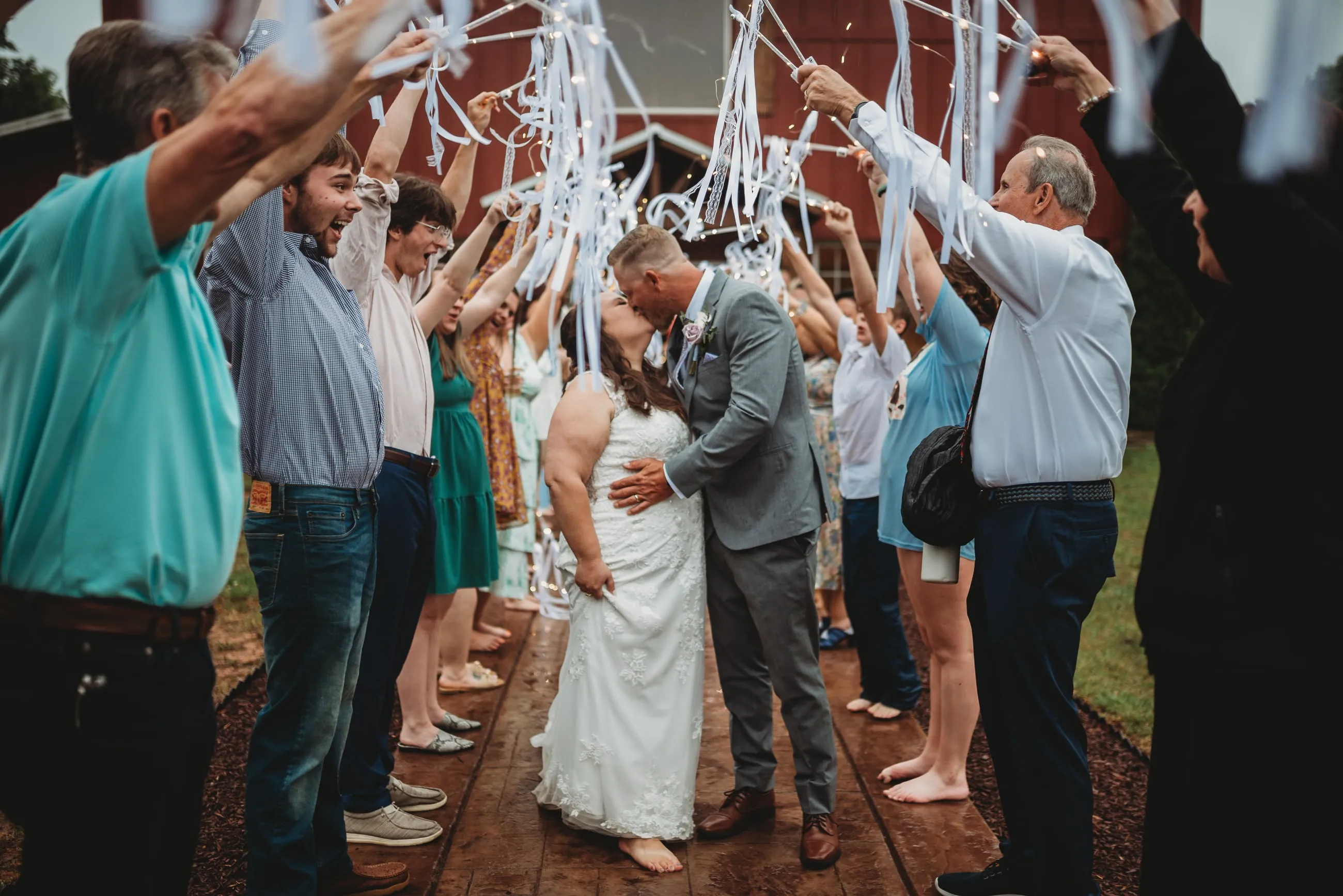 Couple celebrating with guests during their exit at The Heritage Barn